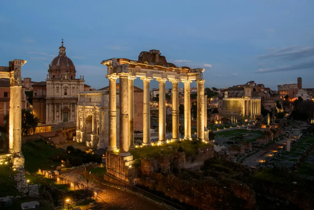 The Roman Forum columns and temples lit up at dusk