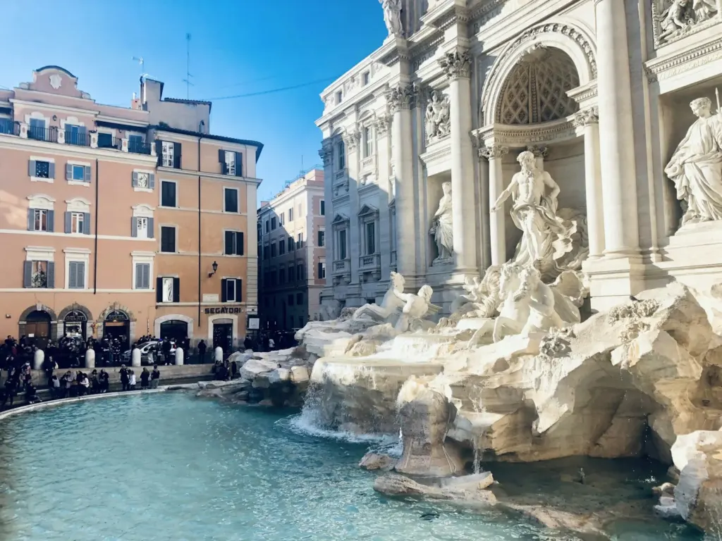 Visitors around the Trevi Fountain with its baroque facade